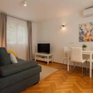 a living room with a couch and a table and a television at Apartman Ivanto in Makarska