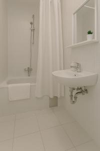 a white bathroom with a sink and a shower at Apartman Ivanto in Makarska +8 photos
