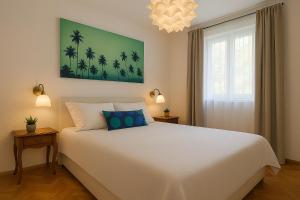 a bedroom with a large white bed with blue pillows at Apartman Ivanto in Makarska