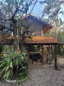 a tree house with a picnic table in front of it at Ecocentro Brasil - Bangalô Panorâmica in São Pedro