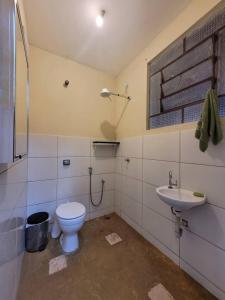 a bathroom with a toilet and a sink at Ecocentro Brasil - Bangalô Panorâmica in São Pedro