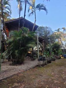 a house with palm trees in front of it at Ecocentro Brasil - Bangalô Panorâmica in São Pedro +26 photos