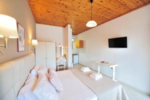 a living room with a white couch and a television at Vista Mare Skiathos in Kolios +30 photos