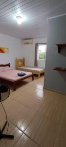 a room with a bed and a table and a window at Suítes Mar e Lar in Cananéia