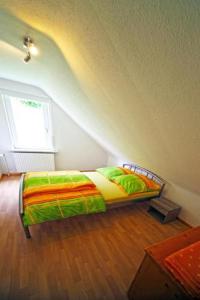 a bedroom with a bed with a colorful comforter at Ferienwohnung Lerbachtal L3 in Osterode