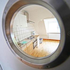 a view of a kitchen through a round mirror at Ferienwohnung Lerbachtal L3 in Osterode