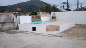 a building with a swimming pool on top of it at Pousada Cauna in Caraguatatuba