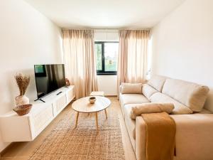 a living room with a couch and a tv at Apartamento Nautilus by ALÔGA in Fisterra