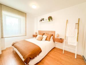 a bedroom with a large bed with a wooden headboard at Apartamento Nautilus by ALÔGA in Fisterra