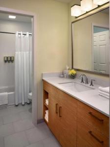 a bathroom with a sink and a shower with a mirror at Sonesta ES Suites Atlanta - Perimeter Center North in Atlanta