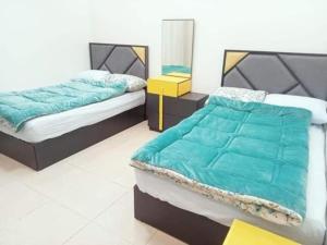 a bedroom with two twin beds and a yellow table at LINCON inn in Aqaba