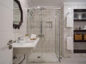 ein weißes Badezimmer mit Waschbecken und Dusche in der Unterkunft Feel Canteras in Las Palmas de Gran Canaria + 37 Fotos