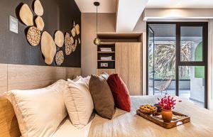 Una cama con almohadas y una bandeja de comida. en Kukun Inspire Polanco, en Ciudad de México