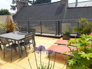 a patio with a table and chairs and plants at Résidence Les Pêcheries in Saint-Vaast-la-Hougue +5 photos