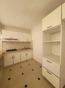 a large white kitchen with white cabinets and a floor at July house in Wadi Musa
