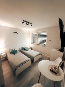 a bedroom with two beds and a table and a tv at Zosieńka in Podolsze