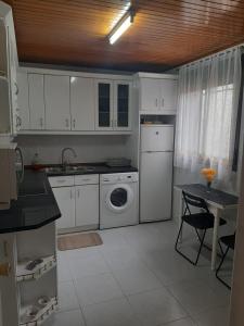 a kitchen with white cabinets and a washing machine at Casa Valeriana Guijosa in Guijosa