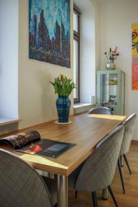 a dining room table with chairs and a vase with flowers at Kulturelles Businessapartment in Toplage in Chemnitz