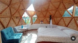 a bedroom with a bed and a chair in a yurt at Esferas Verdes Glamping in Tinjacá
