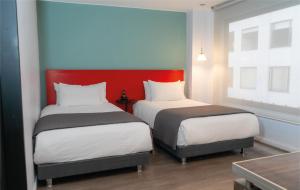 two beds in a room with red and blue walls at Central Apartamentos Bogotá in Bogotá +70 photos