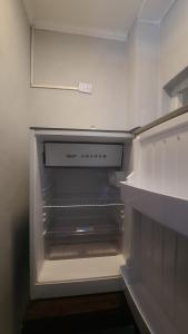 an empty refrigerator with its door open in a kitchen at Departamento in Termas de Río Hondo