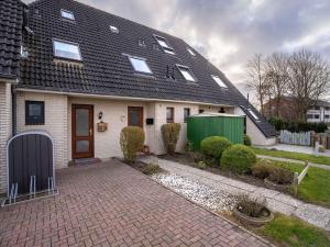 a white house with a black roof and a driveway at Ferienhaus in Büsum für 4 Personen in Büsum