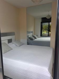 een slaapkamer met twee bedden en een raam bij La Zenia12 in Orihuela