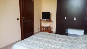 1 dormitorio con 1 cama y TV en una mesa en B&B Castellazzo, en Paceco