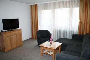 a living room with a couch and a tv at Chiemgau Appartements in Inzell
