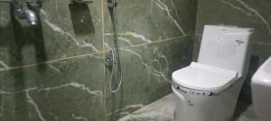 Un baño con ducha y un inodoro. en Hillcrest Prapti Homestay, en Darjeeling