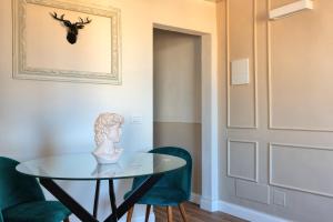 a room with a glass table and two green chairs at NiNNi 12 Apt in Florence