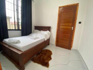 1 dormitorio con 1 cama y 1 perro en el suelo en The Promise Shelter, en Mwanza 9 fotos más