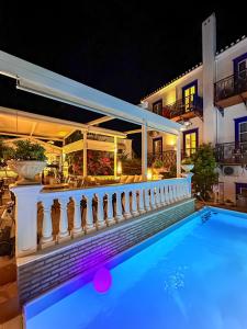 a villa with a swimming pool at night at Armata Boutique Hotel in Spetses