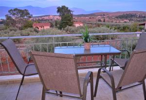 a table and chairs on a balcony with a potted plant at Studio in the Olive Trees ΓΑΛΑΞΙΔΙ in Galaxidi +129 photos