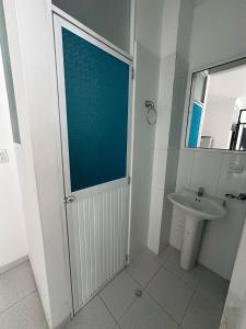 a bathroom with a door with a sink and a toilet at Hotel Rodadero Suites By SGH in Santa Marta +56 photos