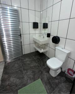 a bathroom with a toilet and a sink at Espaço R&R 2 in São Roque