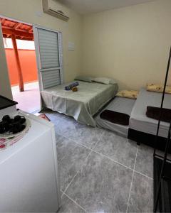 a room with two beds and a refrigerator at Espaço R&R 2 in São Roque