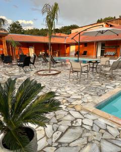 a resort with a pool and chairs and a palm tree at Espaço R&R 2 in São Roque