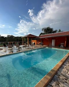 a large swimming pool with chairs and a house at Espaço R&R 2 in São Roque +6 photos