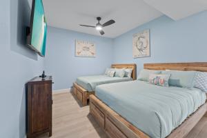 a bedroom with two beds and a flat screen tv at Golf Condo Views With Resort Pool and Amenities in Naples +30 photos