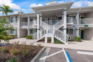 a large apartment building with white balconies at Golf Condo Views With Resort Pool and Amenities in Naples
