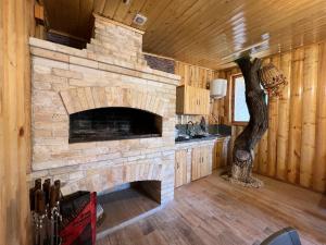 a living room with a stone fireplace in a cabin at Garden House in Yerevan