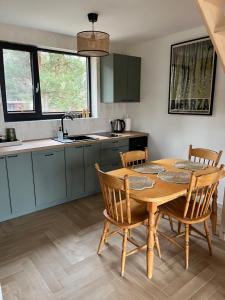 a kitchen with a wooden table and chairs in a kitchen at Biebrzaski - dom nad Biebrzą in Wierciszewo