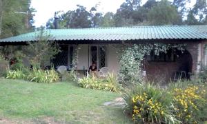 Eine Frau, die am Fenster eines Hauses sitzt. in der Unterkunft Annasrus Mountain Cottage in Champagne Valley