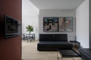 a living room with a black couch and a table at Aparthotel Allada 3* in Barcelona