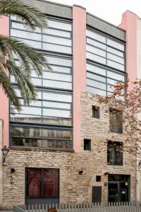 バルセロナにあるアパートホテル アラダ 3*の大きなガラス窓のあるオフィスビル