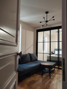 a living room with a blue couch and a table at Magnolia Urban Apartments, Corfu Town in Ágios Rókkos