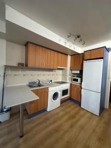 een keuken met een witte koelkast en een vaatwasser bij Apartamento La brisa Fiscal in Fiscal +8 foto's