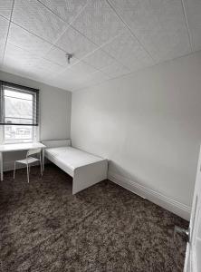 a white room with a bed and a window at Rooms available downtown Winnipeg in Winnipeg