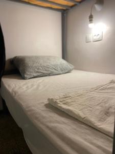 a bed with a pillow on it in a room at Hostel le Rhumel in Constantine